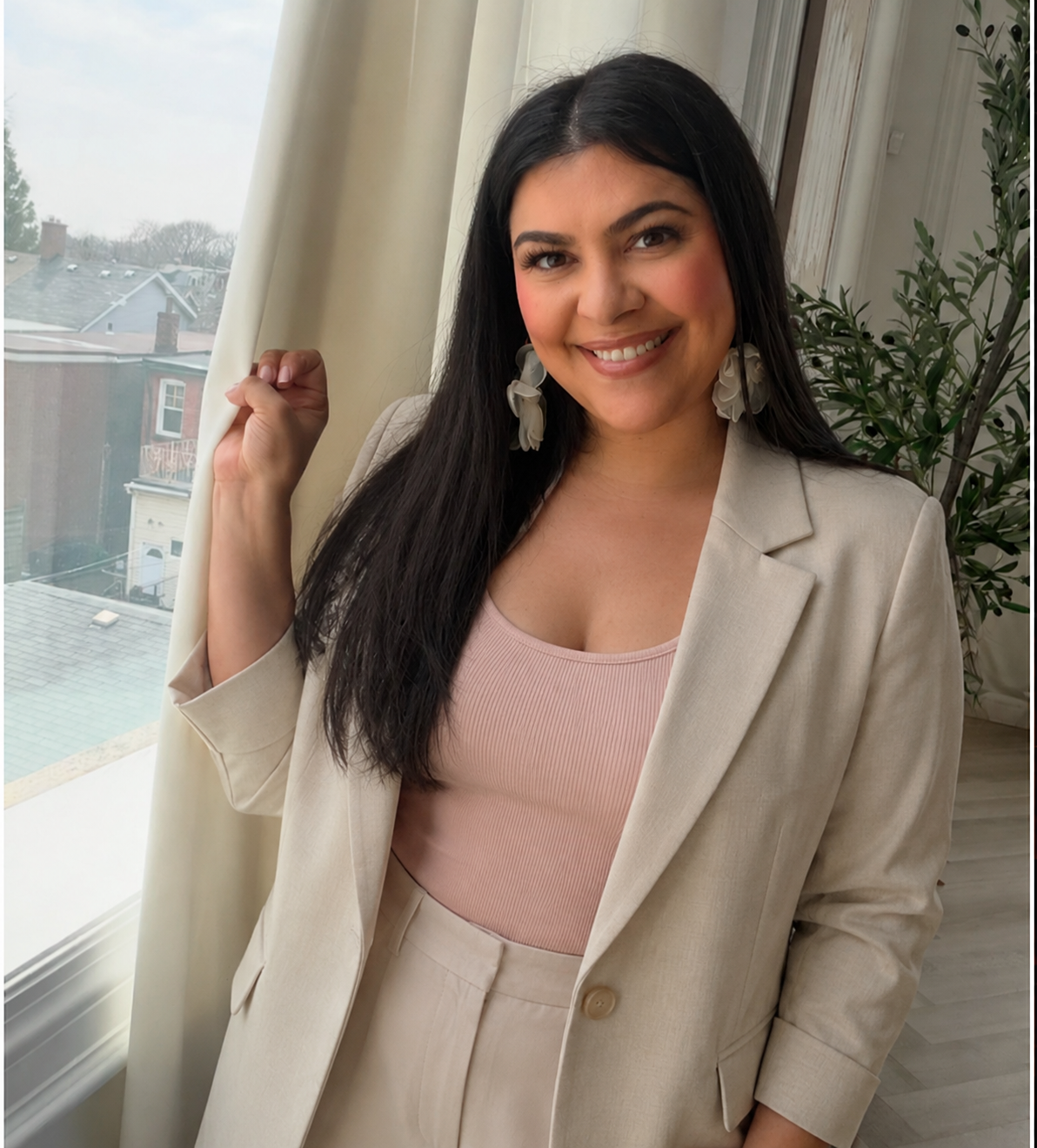 Juliana Provenzano smiling by a window in a cream blazer and blush pink top